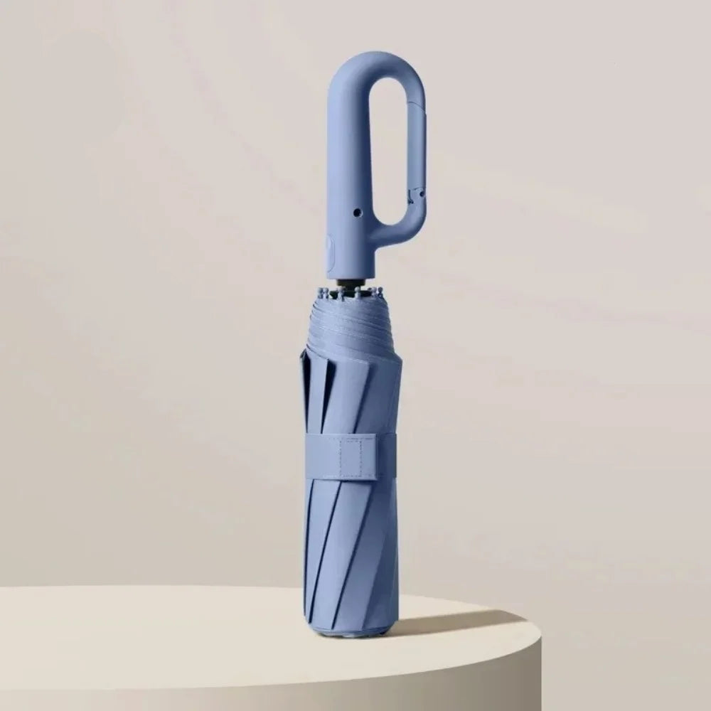 Blue umbrella with a handle on a beige background, featuring UPF50+ label.