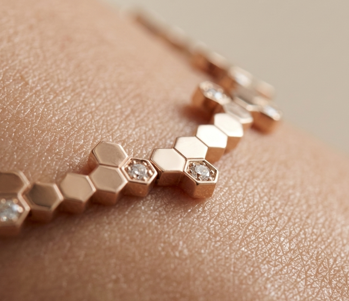Veruccia Rose gold necklace with hexagonal links and embedded diamonds on a skin-toned surface