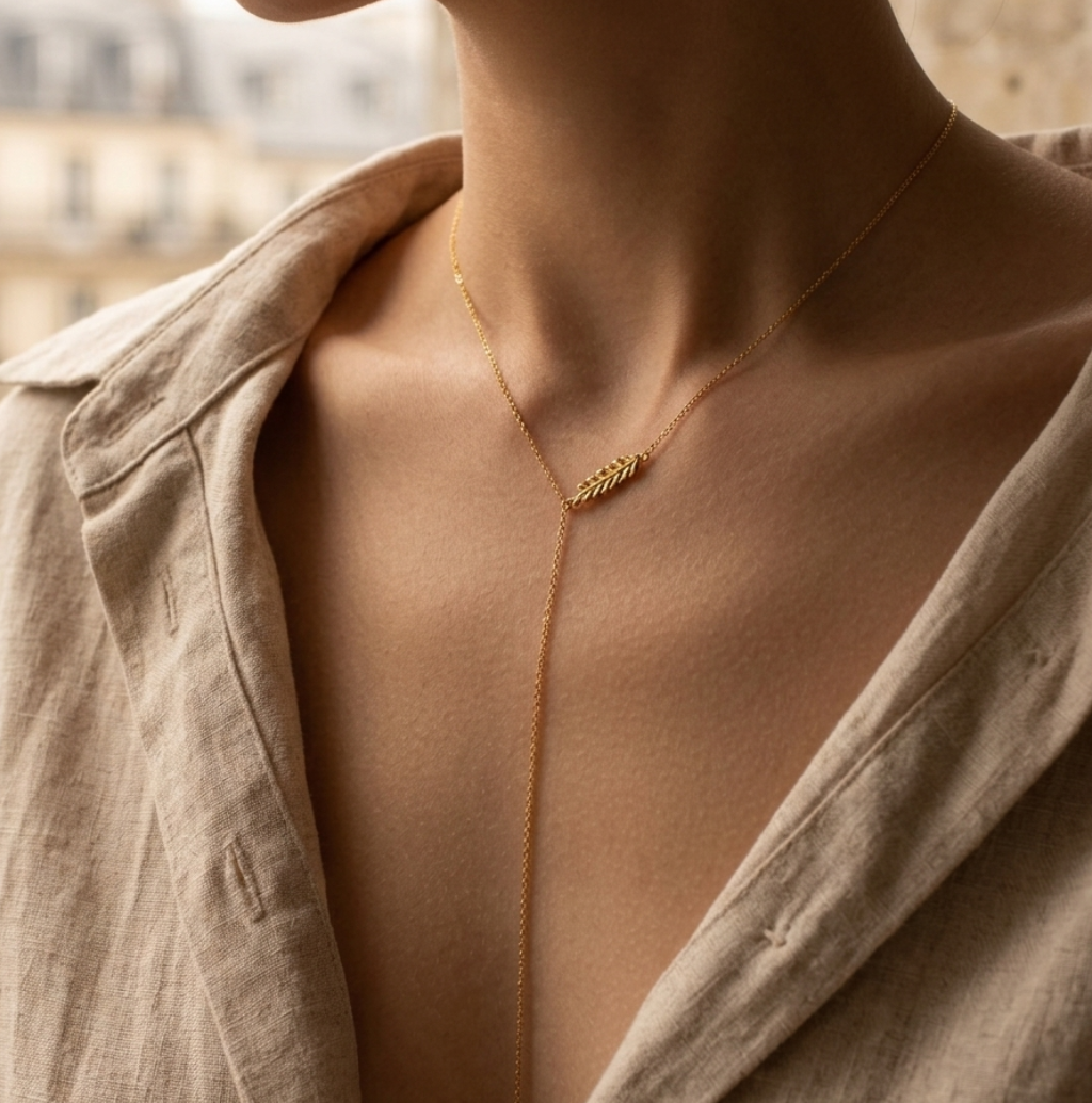 Woman wearing a delicate Veruccia gold necklace with a blurred cityscape background