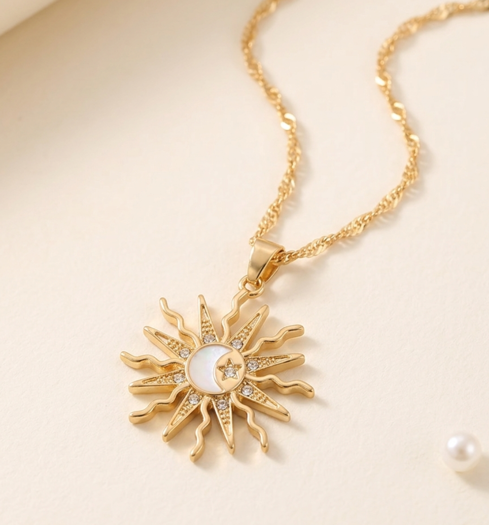 Gold sun-shaped necklace with a pearl center on a beige background