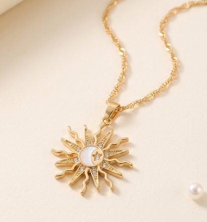 Gold sun-shaped necklace with a pearl center on a beige background