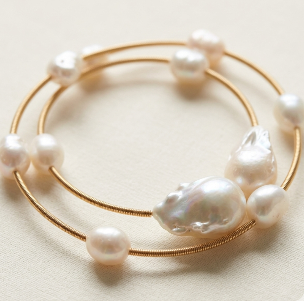 Gold bracelet with pearls on a light beige background