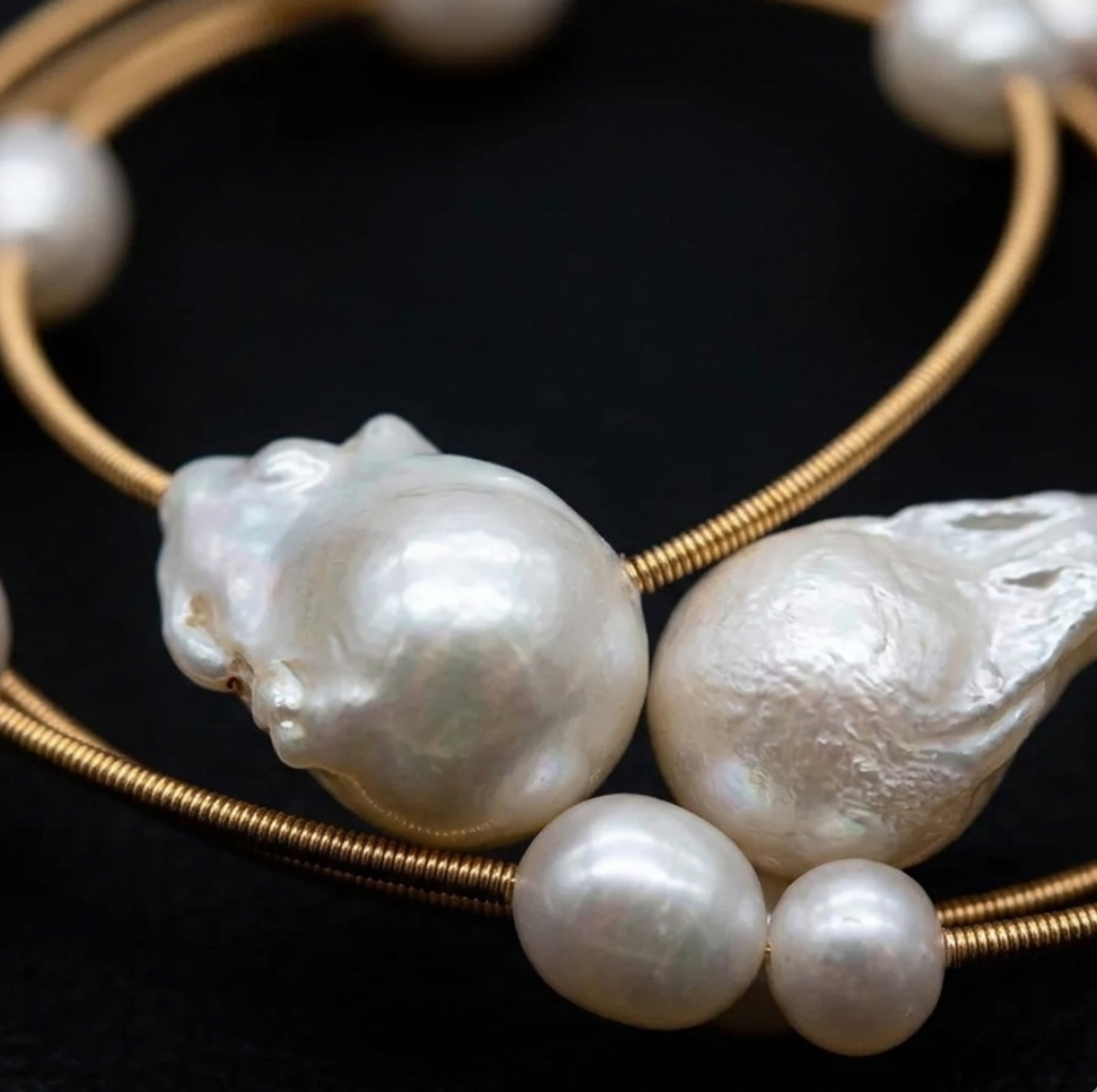 Gold bracelet with pearls on a black background