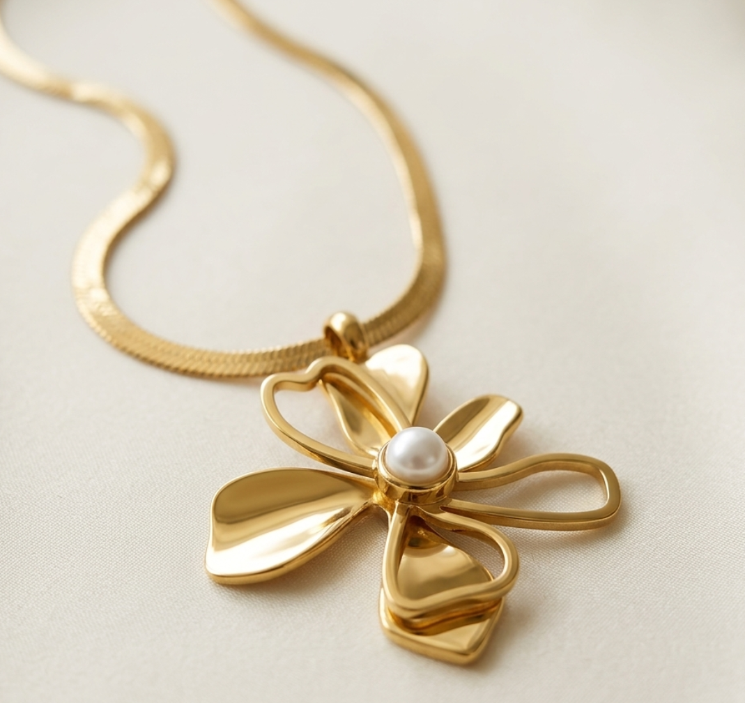 Gold necklace with a floral pendant on a light background