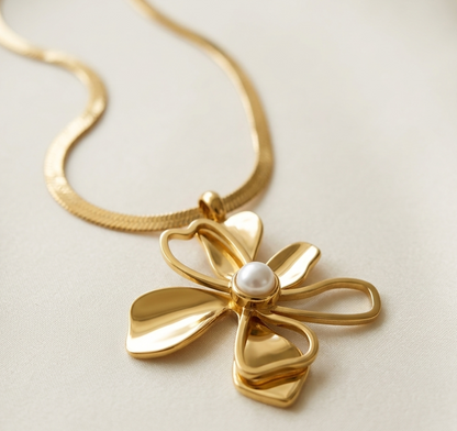 Gold necklace with a floral pendant on a light background