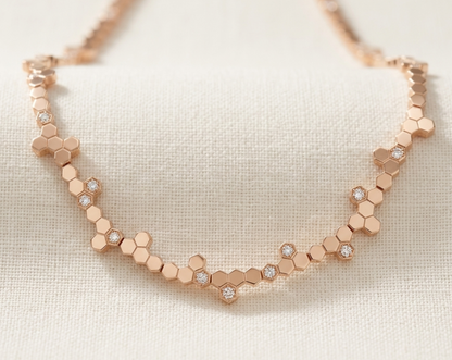 Rose gold hexagonal necklace on a light background