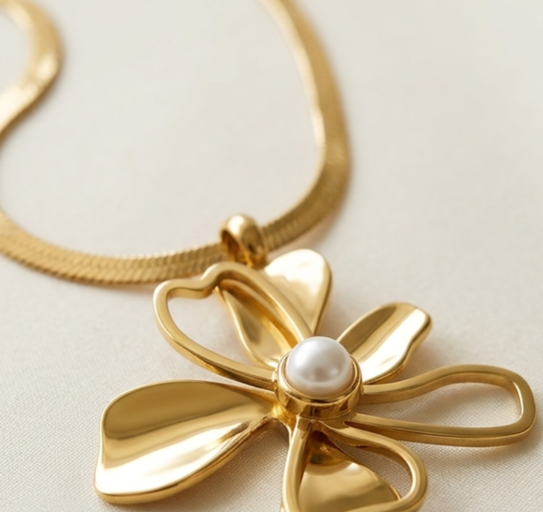 Gold necklace with a floral pendant on a light background