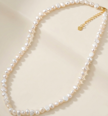 Pearl necklace with a gold chain on a light beige background
