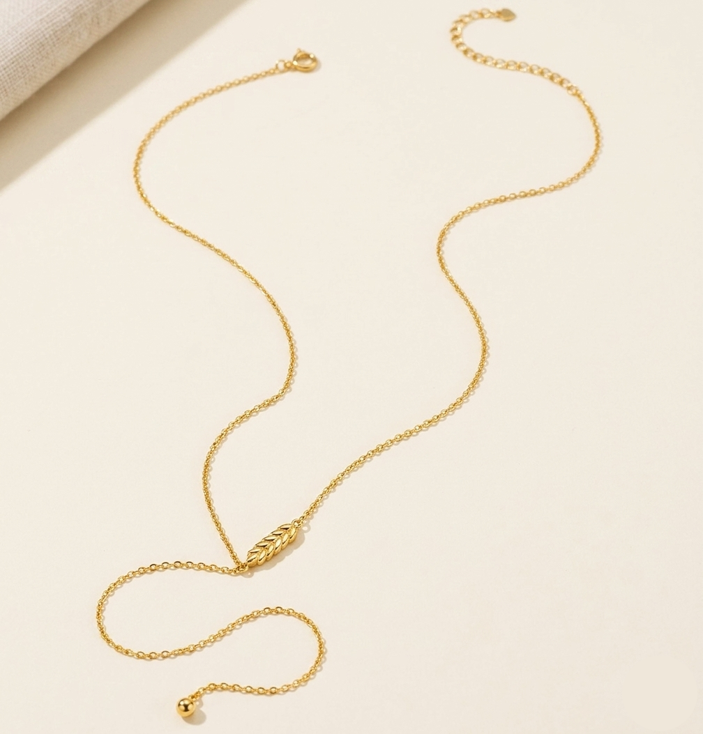 Gold necklace on a light beige surface