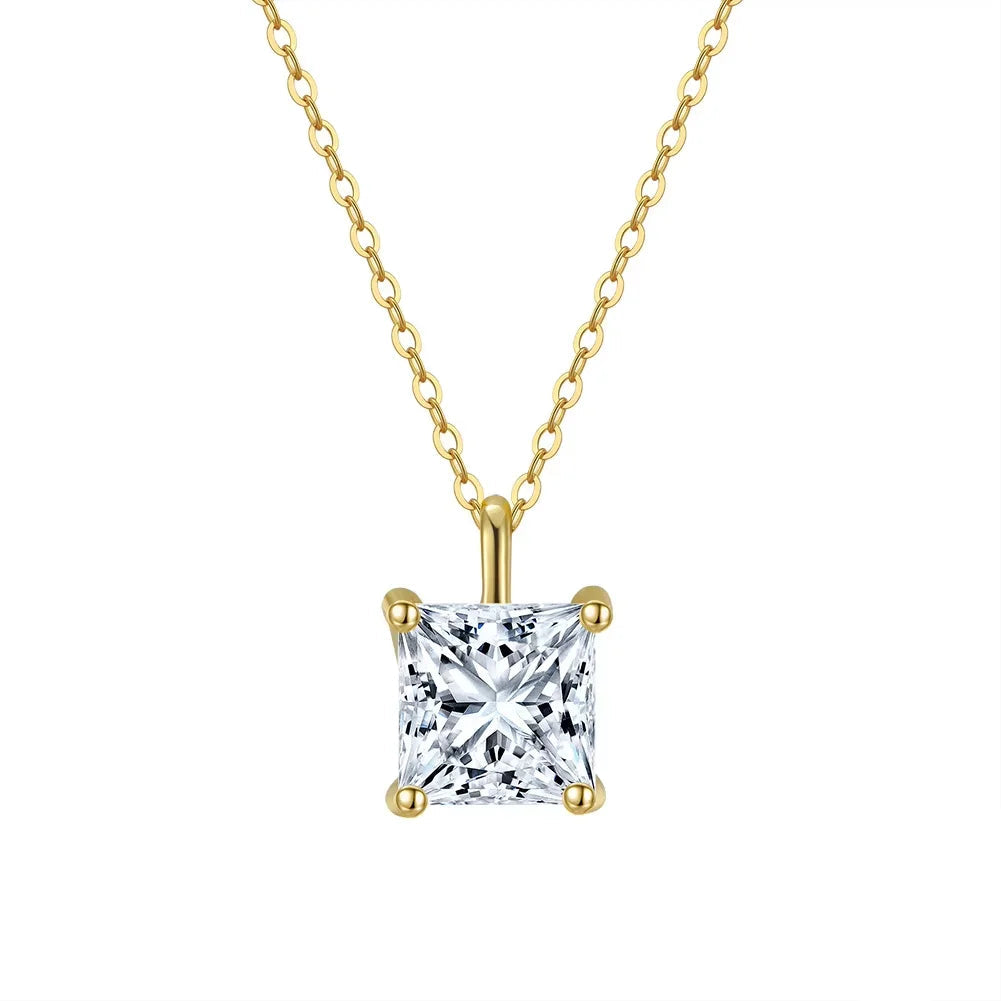 Gold necklace with a square shaped cubic zirconia gemstone pendant on a white background