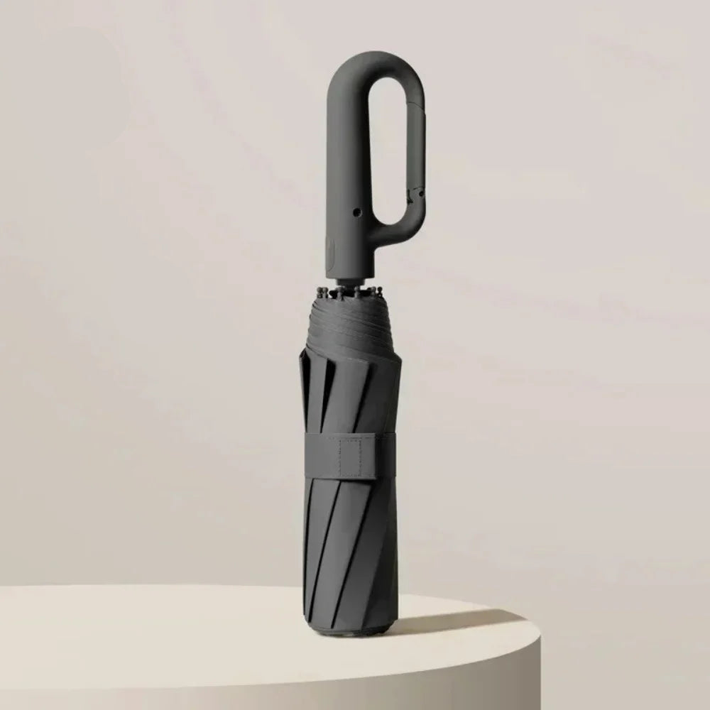 Black umbrella with UPF50+ label on a light beige background
