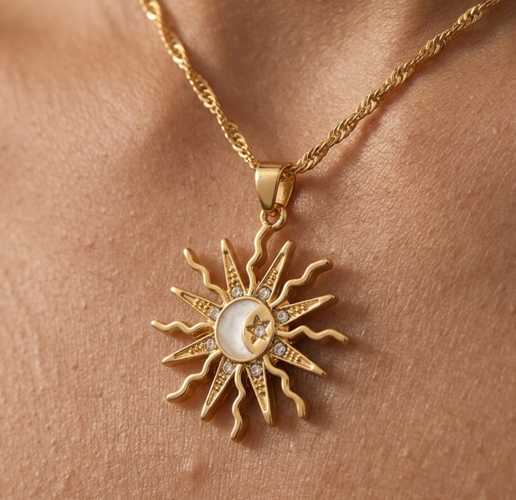 Gold necklace with sun and moon pendant on skin