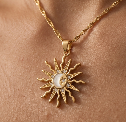 Gold necklace with sun and moon pendant on skin